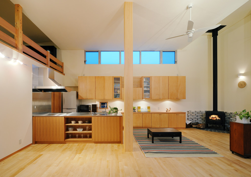 Diseño de salón abierto nórdico con paredes blancas, suelo de madera clara, chimenea de esquina y marco de chimenea de baldosas y/o azulejos