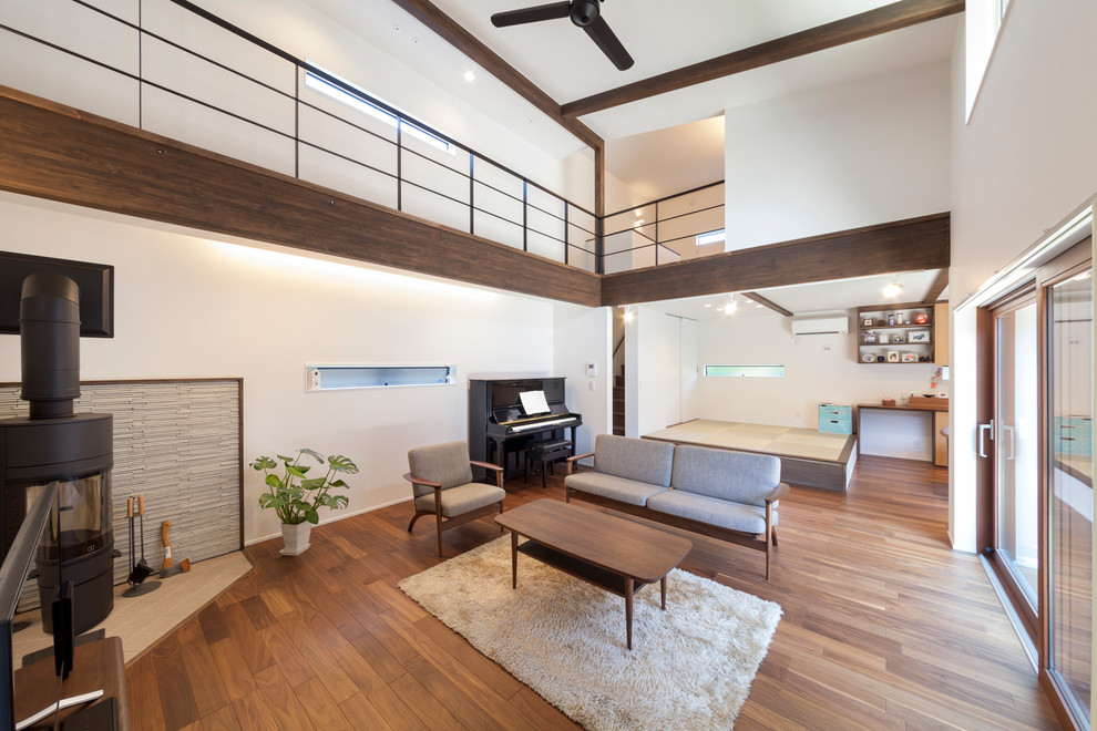 Idéer för ett vardagsrum, med vita väggar, en öppen vedspis och brunt golv