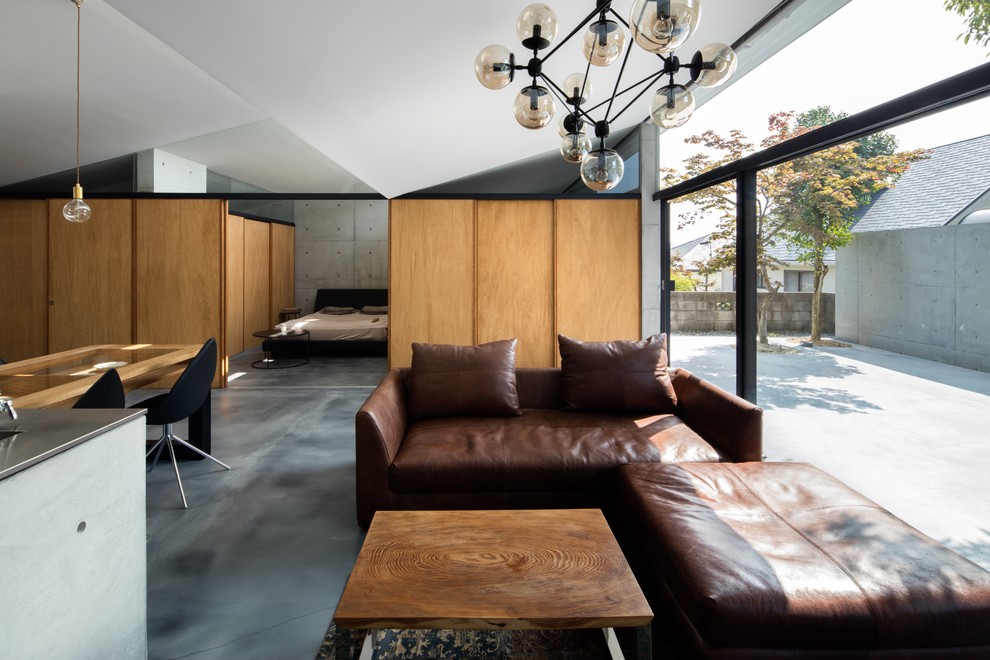Idée de décoration pour un salon design ouvert avec un mur gris et un sol gris.