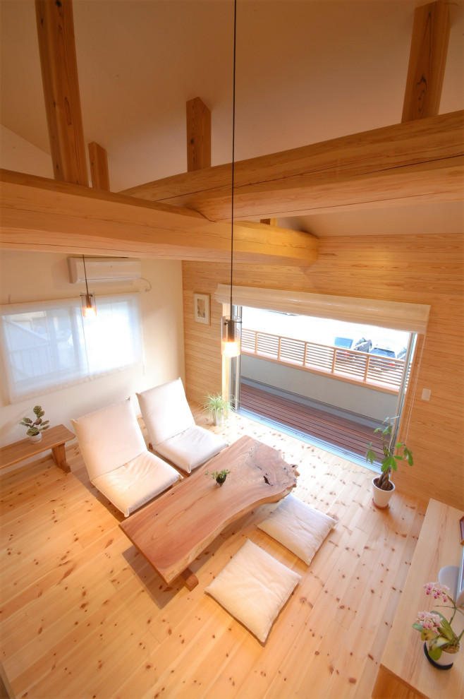 Foto på ett litet orientaliskt loftrum, med beige väggar, ljust trägolv, en fristående TV och beiget golv