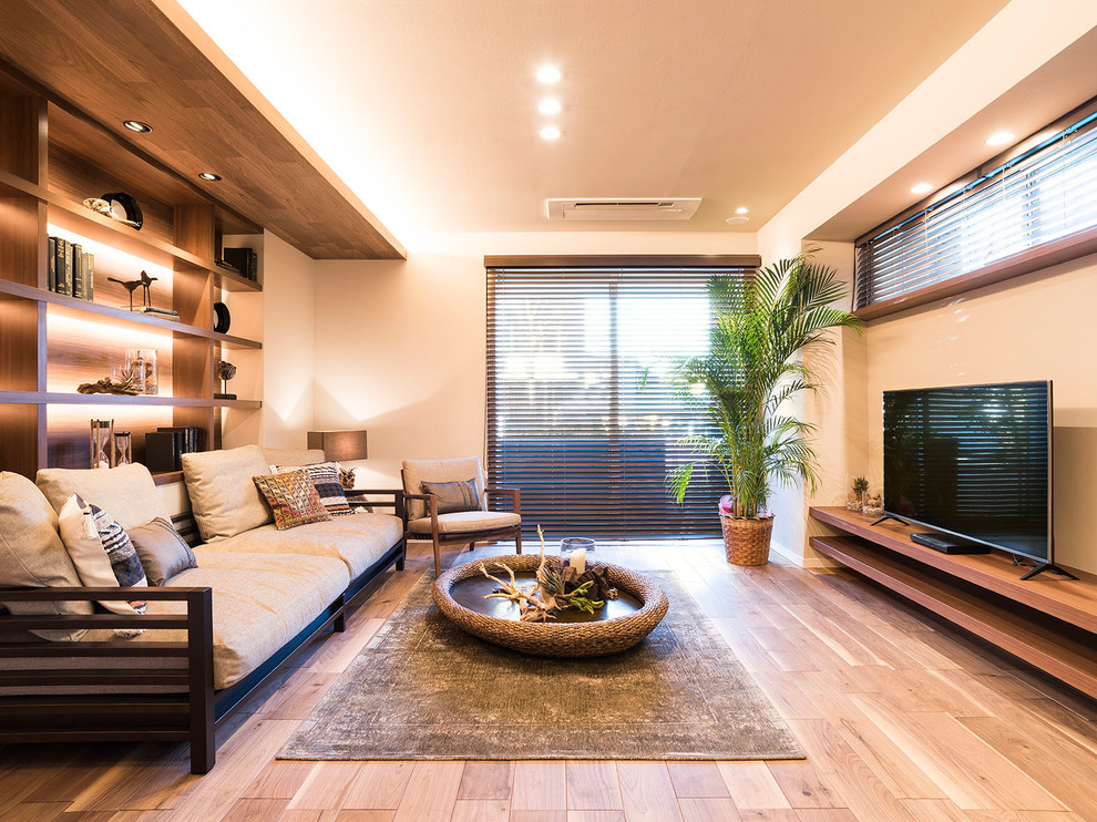 Источник вдохновения для домашнего уюта: гостиная комната в восточном стиле с отдельно стоящим телевизором, полом из фанеры и коричневым полом без камина