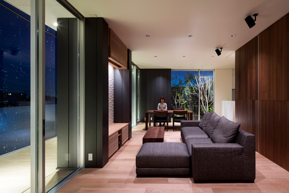 Idee per un soggiorno moderno di medie dimensioni e aperto con pareti marroni, pavimento in compensato, nessun camino e TV autoportante