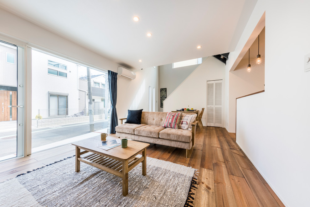 Modernes Wohnzimmer mit weißer Wandfarbe, braunem Holzboden und braunem Boden in Tokio Peripherie