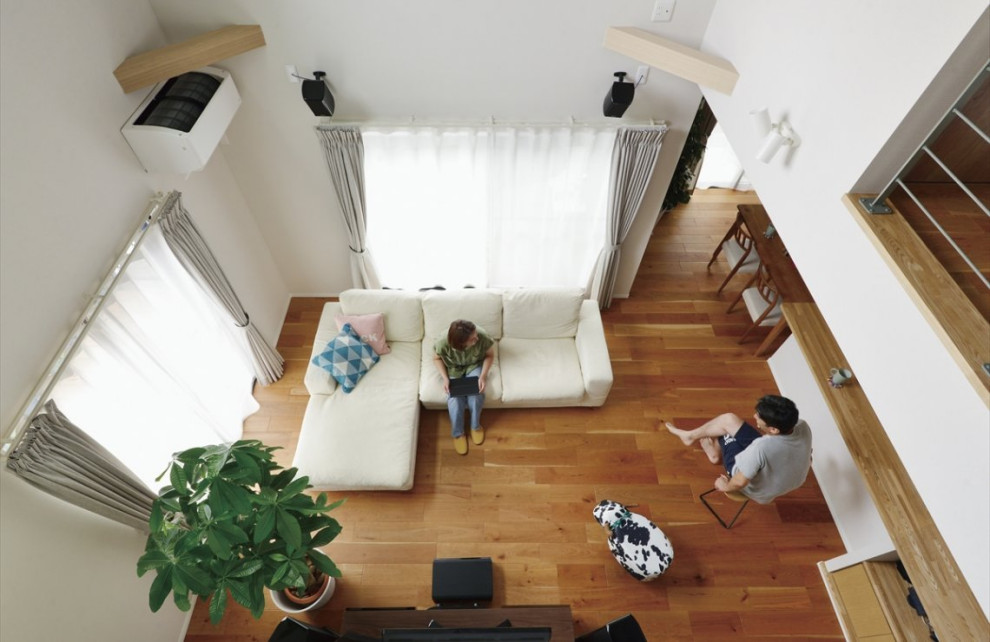 Exempel på ett mellanstort industriellt allrum med öppen planlösning, med vita väggar, mellanmörkt trägolv, en fristående TV och brunt golv