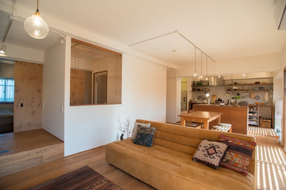 Idées déco pour un salon contemporain ouvert avec un mur blanc, un sol en bois brun et un sol marron.