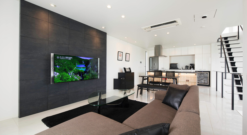 На фото: открытая гостиная комната в современном стиле с разноцветными стенами, телевизором на стене и белым полом с