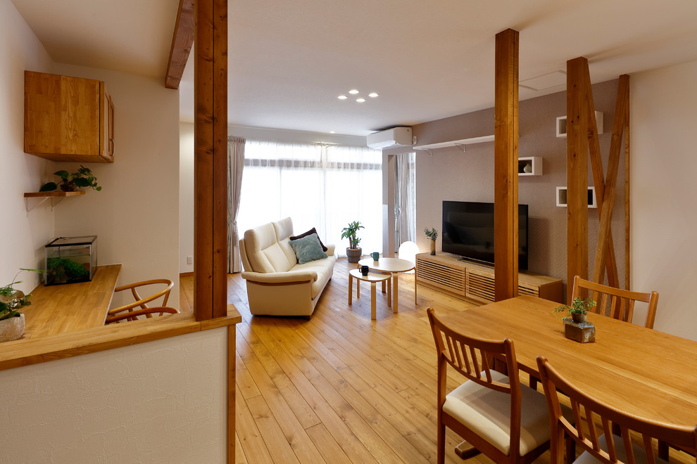 Источник вдохновения для домашнего уюта: открытая гостиная комната в скандинавском стиле с белыми стенами, паркетным полом среднего тона, отдельно стоящим телевизором и коричневым полом