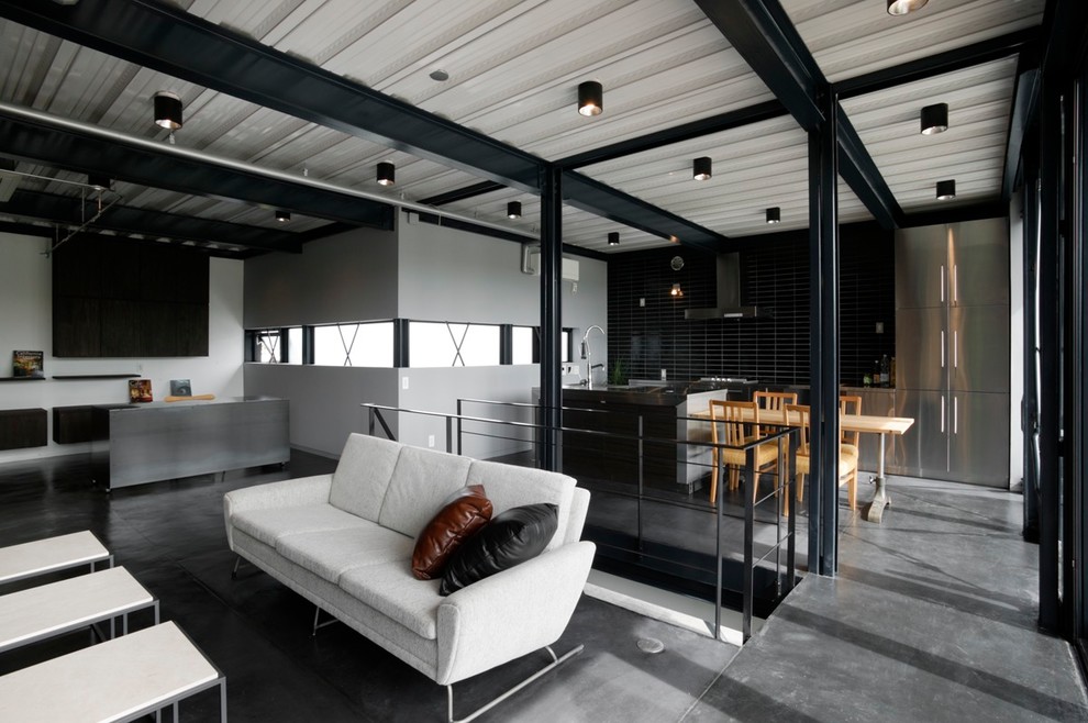 Стильный дизайн: гостиная комната в стиле лофт с разноцветными стенами и серым полом - последний тренд