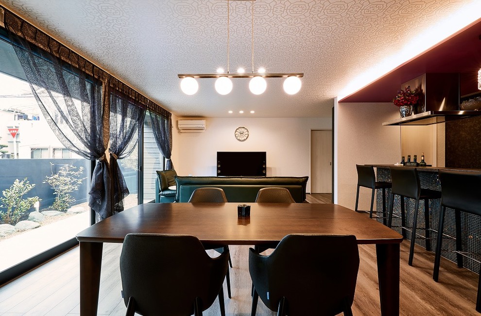 Cette photo montre un salon tendance ouvert avec un bar de salon, un mur blanc, un sol en contreplaqué, aucune cheminée, un téléviseur indépendant et un sol marron.