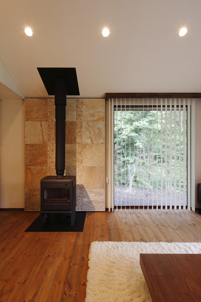 This is an example of a medium sized contemporary formal open plan living room in Other with white walls, medium hardwood flooring, a wood burning stove, a tiled fireplace surround, no tv and brown floors.