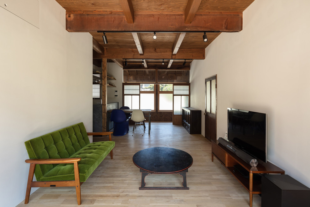 Imagen de salón abierto de estilo zen de tamaño medio con paredes blancas, suelo de madera clara, televisor independiente y suelo marrón