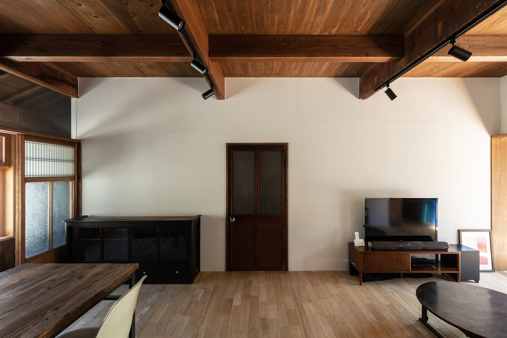 Immagine di un soggiorno moderno di medie dimensioni e aperto con pareti bianche, parquet chiaro, TV autoportante e pavimento marrone
