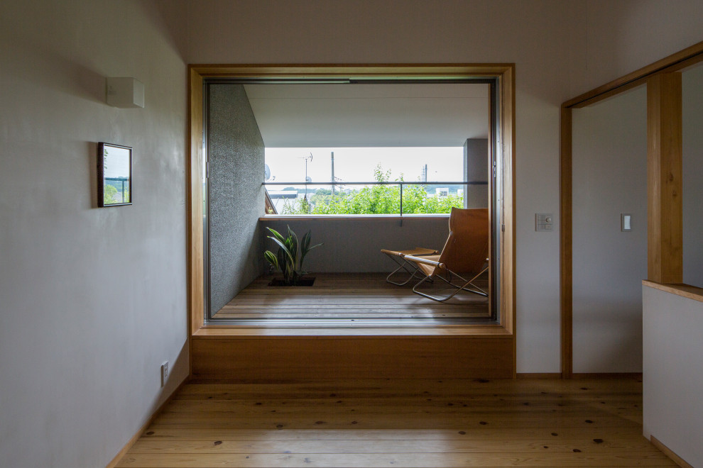 Kleines, Fernseherloses, Abgetrenntes Modernes Wohnzimmer ohne Kamin mit Hausbar, weißer Wandfarbe, braunem Holzboden und weißem Boden in Sonstige