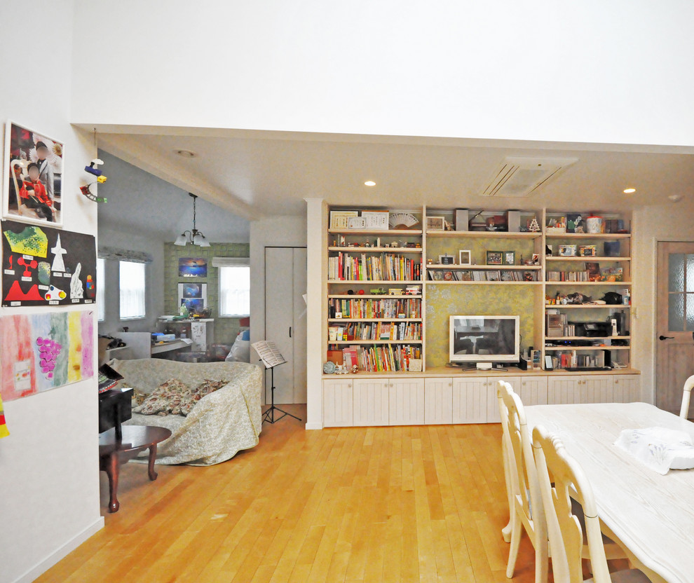 Источник вдохновения для домашнего уюта: большая открытая гостиная комната с белыми стенами, кирпичным полом, отдельно стоящим телевизором и оранжевым полом