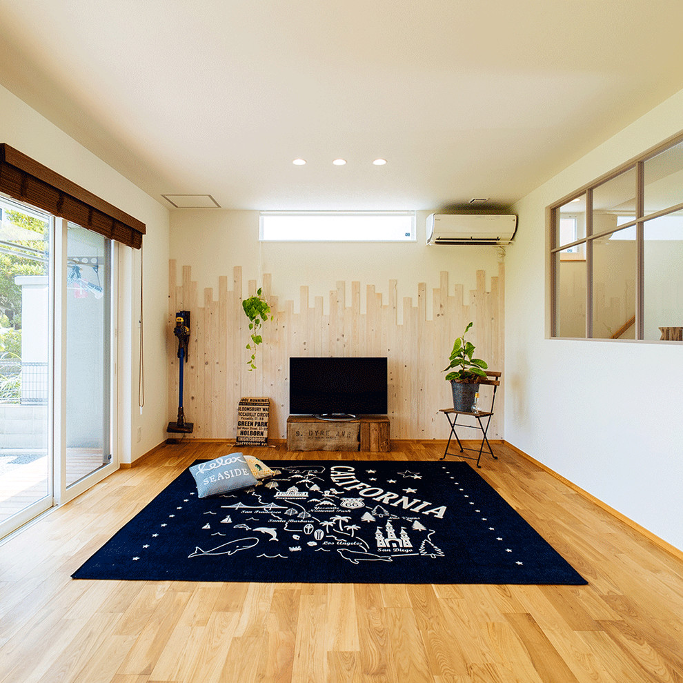 Foto de salón escandinavo con paredes blancas, suelo de madera en tonos medios, televisor independiente y suelo marrón
