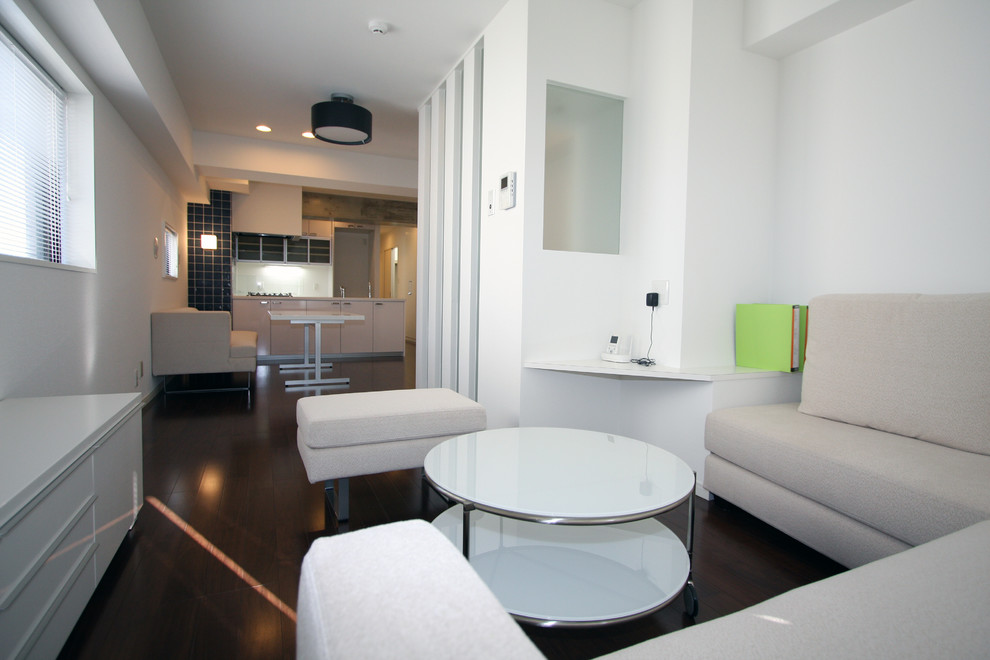 Photo of a large modern open plan living room in Tokyo with white walls, painted wood flooring and a freestanding tv.