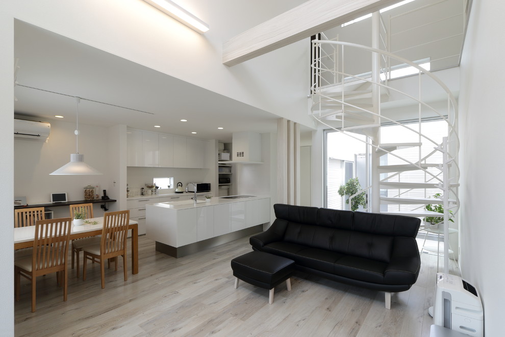 Offenes Modernes Wohnzimmer mit weißer Wandfarbe, gebeiztem Holzboden und grauem Boden in Sonstige