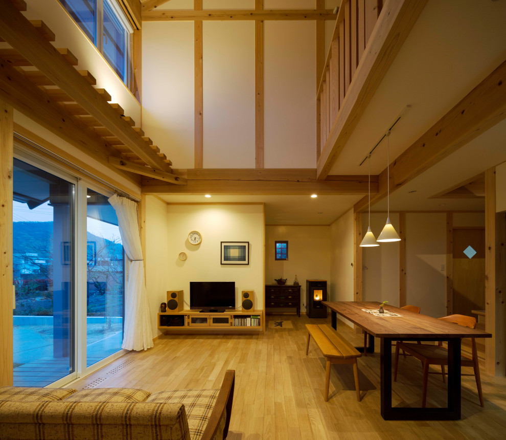 Diseño de salón abierto de estilo zen de tamaño medio con paredes blancas, suelo de madera clara, marco de chimenea de yeso y televisor independiente