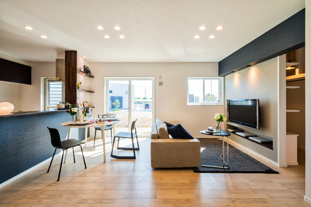 Idee per un soggiorno etnico con pareti bianche, pavimento in legno massello medio, TV a parete e pavimento marrone