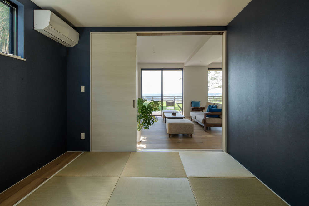 Foto di un grande soggiorno moderno aperto con pareti bianche, pavimento in tatami e TV a parete