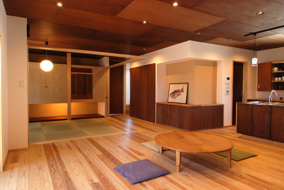 На фото: открытая гостиная комната в восточном стиле с белыми стенами, паркетным полом среднего тона и коричневым полом с