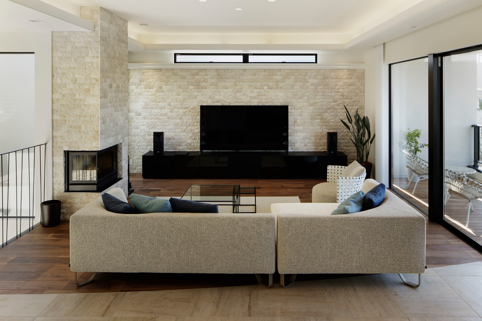 Photo of a mediterranean living room in Other with beige walls, dark hardwood flooring, a freestanding tv and brown floors.