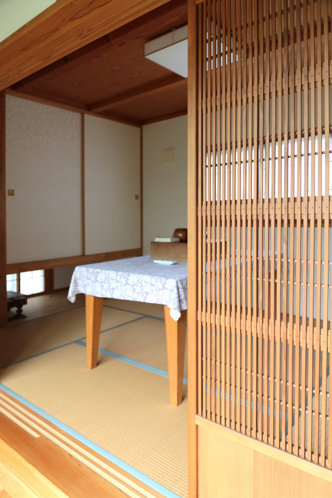 Exemple d'un salon de taille moyenne et fermé avec une salle de réception, un mur blanc, un sol de tatami, aucune cheminée, aucun téléviseur et un sol beige.