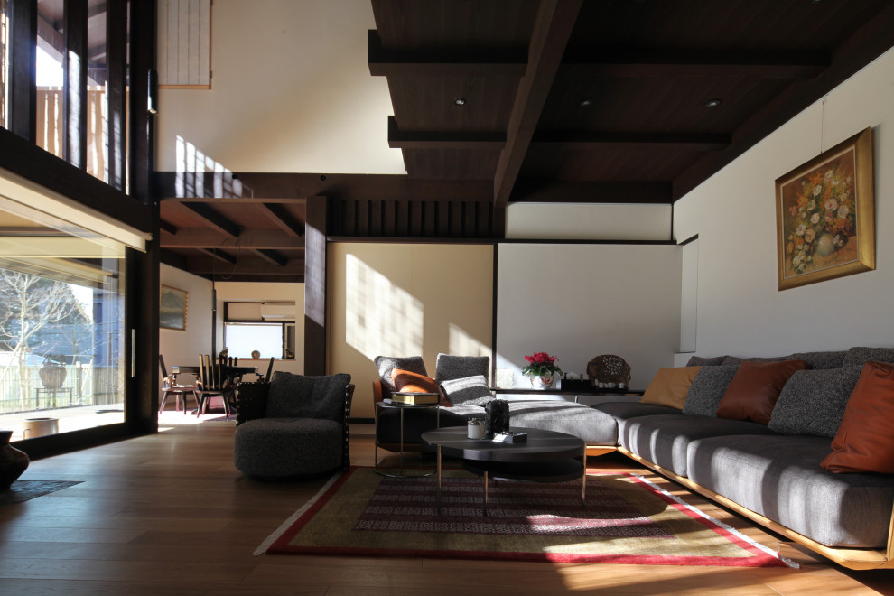 Inspiration för ett orientaliskt vardagsrum, med vita väggar, mellanmörkt trägolv och brunt golv