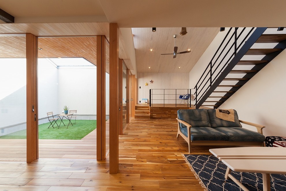 Idéer för ett modernt allrum med öppen planlösning, med vita väggar, mellanmörkt trägolv och brunt golv
