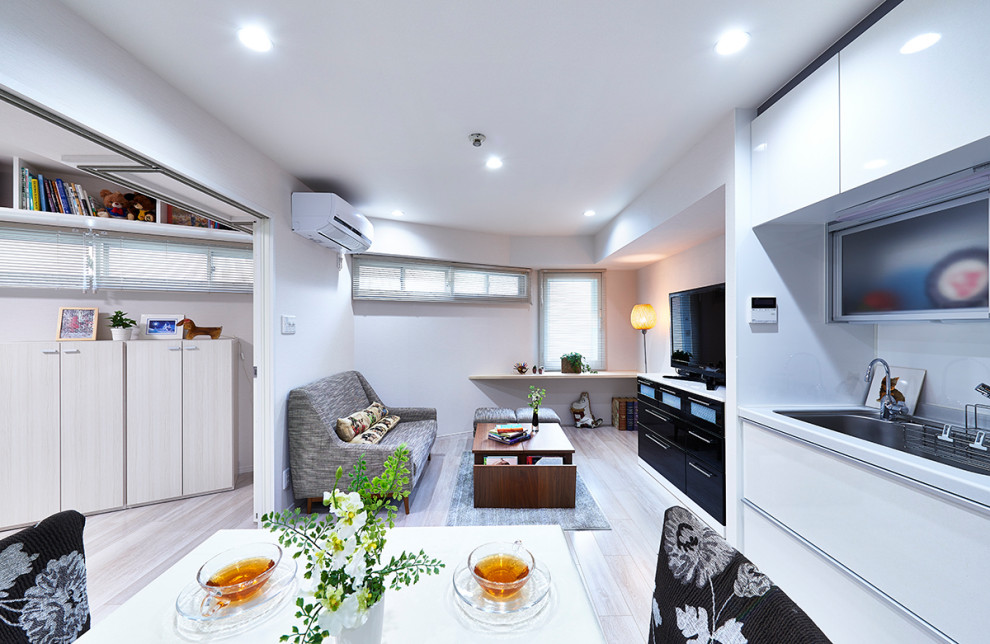 Esempio di un piccolo soggiorno moderno aperto con pareti bianche, pavimento in compensato, TV autoportante e pavimento bianco