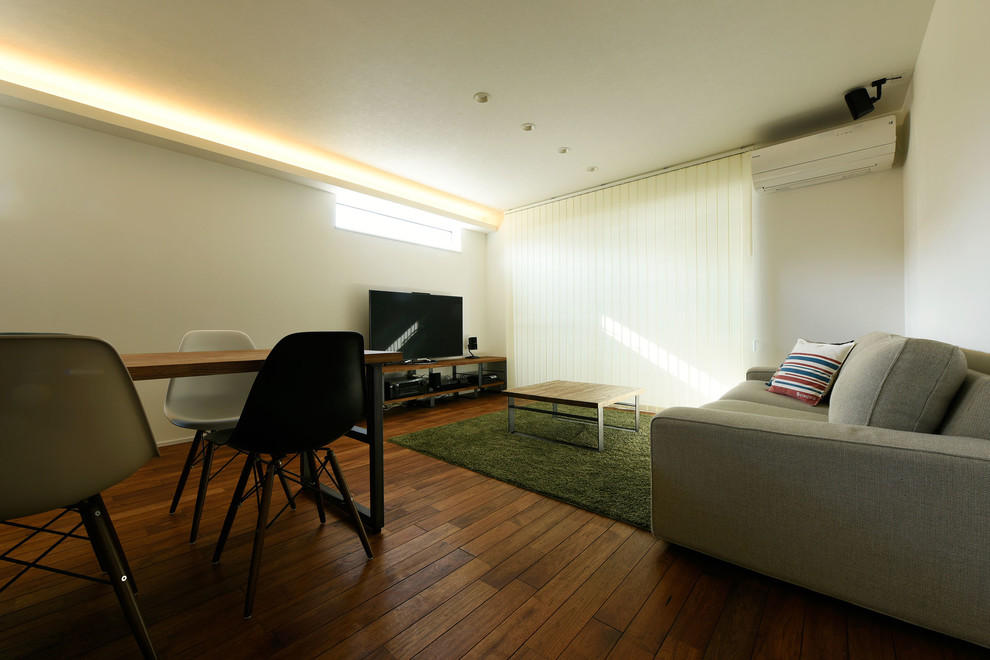 Immagine di un soggiorno minimalista aperto con pareti bianche, pavimento in vinile, nessun camino e TV autoportante
