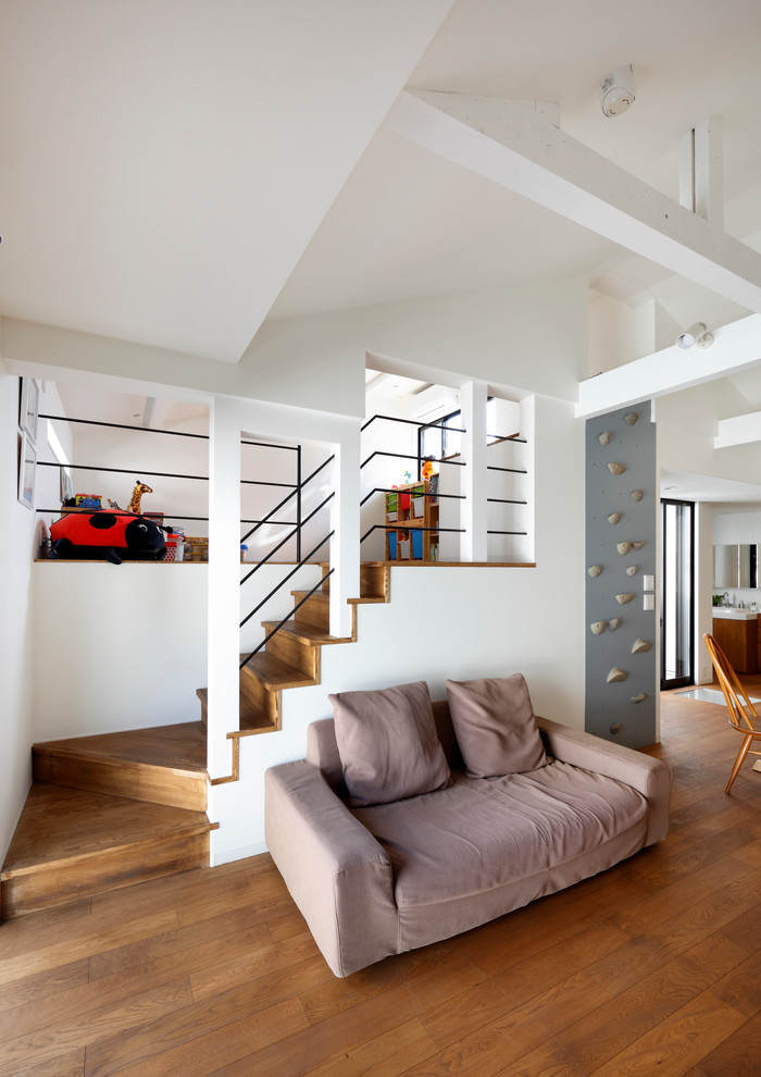 Foto på ett minimalistiskt allrum med öppen planlösning, med vita väggar, mellanmörkt trägolv och brunt golv