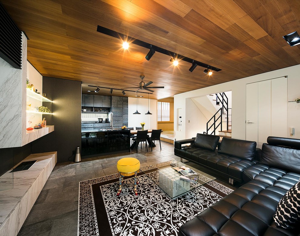 На фото: изолированная гостиная комната в стиле фьюжн с бежевыми стенами, татами, телевизором на стене и серым полом