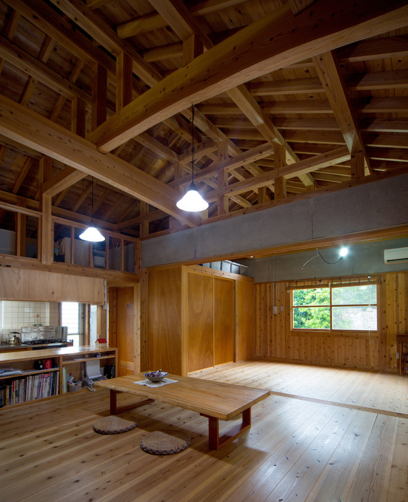 Foto de salón abierto asiático con paredes marrones y suelo de madera en tonos medios