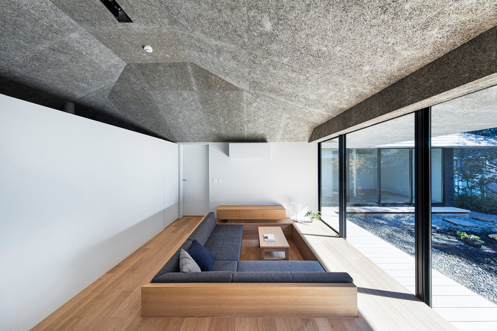 Idee per un soggiorno minimal aperto con pareti bianche, parquet chiaro e pavimento marrone