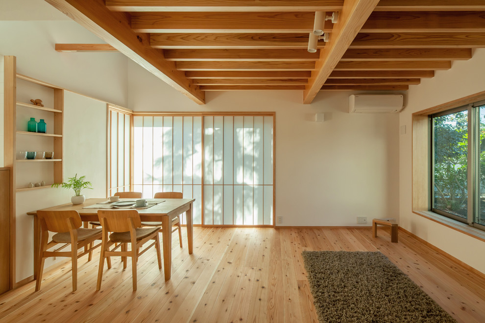 Foto på ett litet funkis allrum med öppen planlösning, med vita väggar, mellanmörkt trägolv och brunt golv