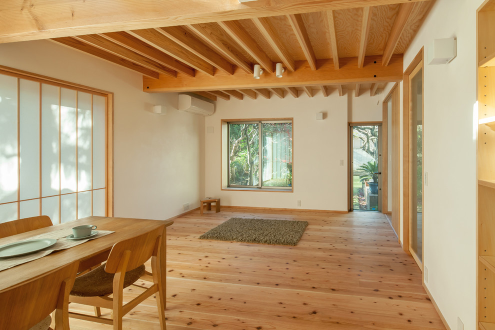 Ejemplo de salón abierto moderno pequeño con paredes blancas, suelo de madera en tonos medios y suelo marrón
