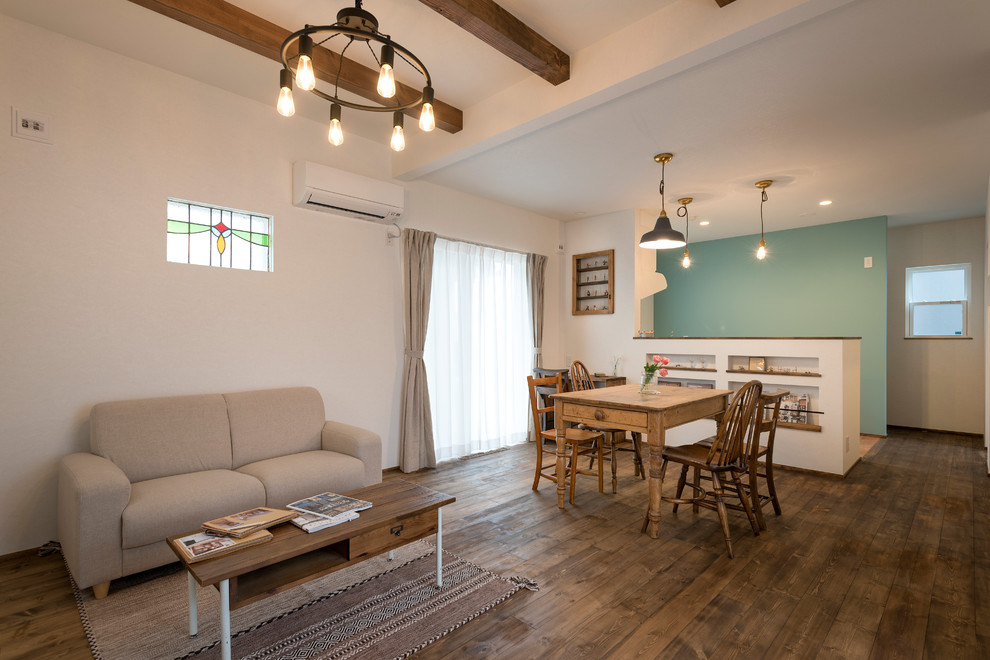 Immagine di un soggiorno country con pareti bianche, pavimento in legno massello medio e pavimento marrone