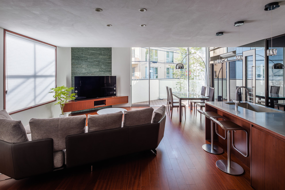 Idee per un soggiorno design con pareti bianche, pavimento in legno massello medio, TV autoportante e pavimento marrone