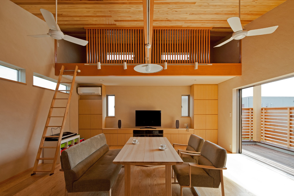 Asiatisches Wohnzimmer ohne Kamin mit beiger Wandfarbe, hellem Holzboden, freistehendem TV und beigem Boden in Sonstige
