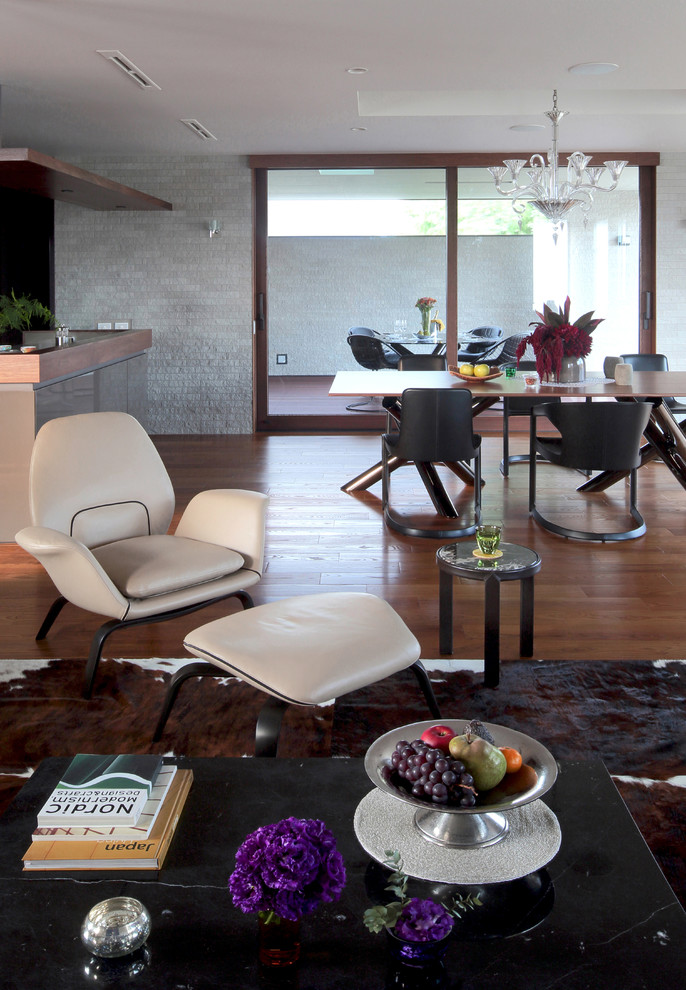Cette image montre un salon design avec un mur gris, un sol en bois brun et un sol marron.