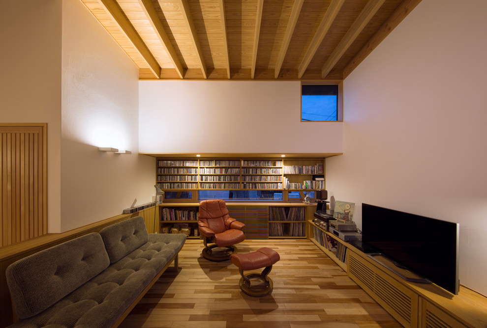Imagen de salón abierto asiático con paredes blancas, suelo de madera en tonos medios, televisor independiente y suelo marrón
