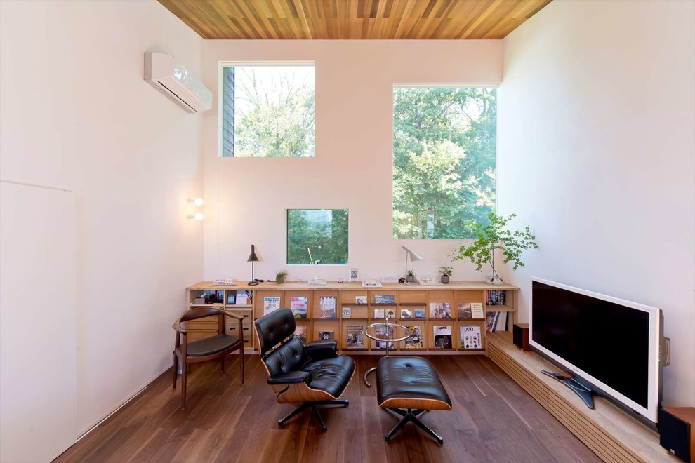 Asiatisches Wohnzimmer mit weißer Wandfarbe, dunklem Holzboden, freistehendem TV und braunem Boden in Sonstige