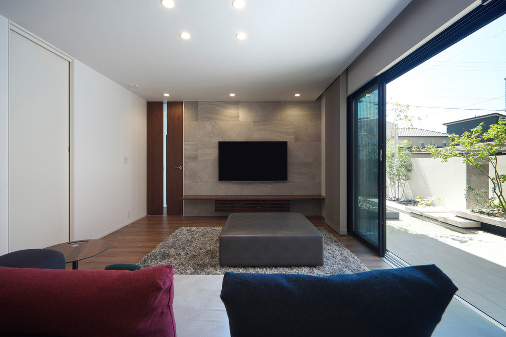 Bild på ett funkis vardagsrum, med flerfärgade väggar, mörkt trägolv, en väggmonterad TV och brunt golv