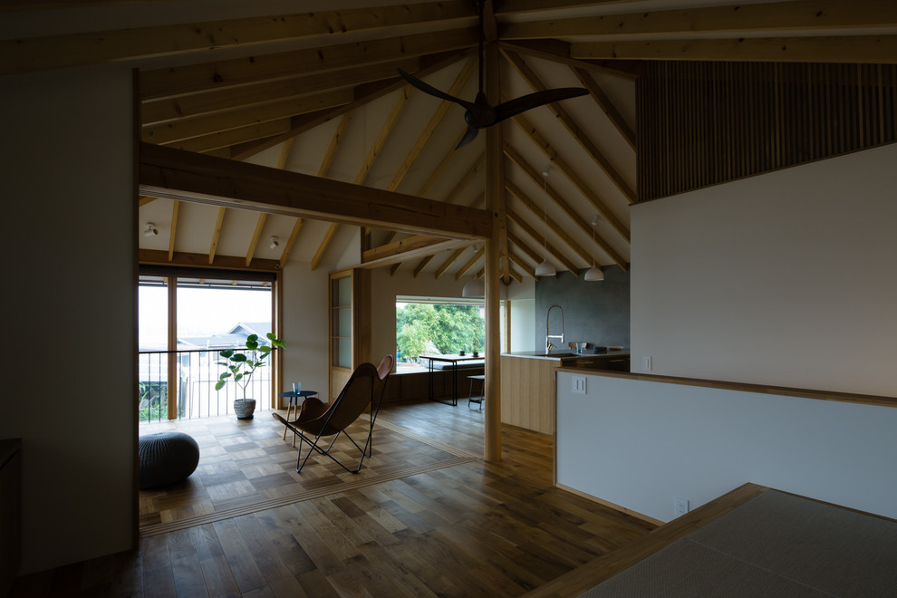 Modelo de salón abierto minimalista pequeño sin chimenea con paredes blancas, suelo de madera en tonos medios y televisor independiente