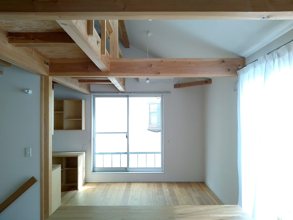 This is an example of a scandi open plan living room in Tokyo with white walls and light hardwood flooring.