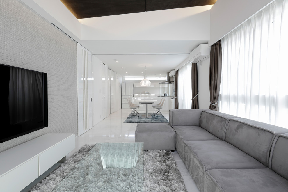 Diseño de salón abierto actual con paredes blancas, televisor colgado en la pared y suelo blanco