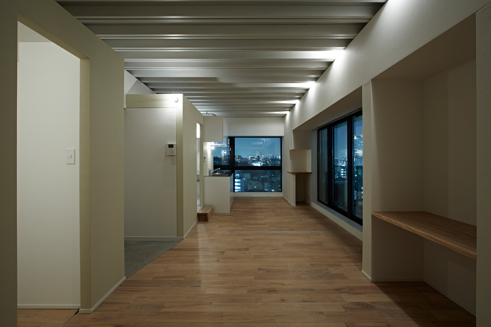 Offenes Modernes Wohnzimmer mit weißer Wandfarbe, hellem Holzboden und beigem Boden in Tokio
