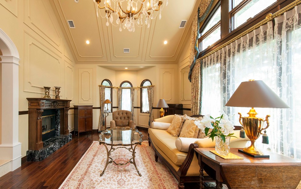 Klassisches Wohnzimmer mit beiger Wandfarbe, dunklem Holzboden und braunem Boden in Sonstige