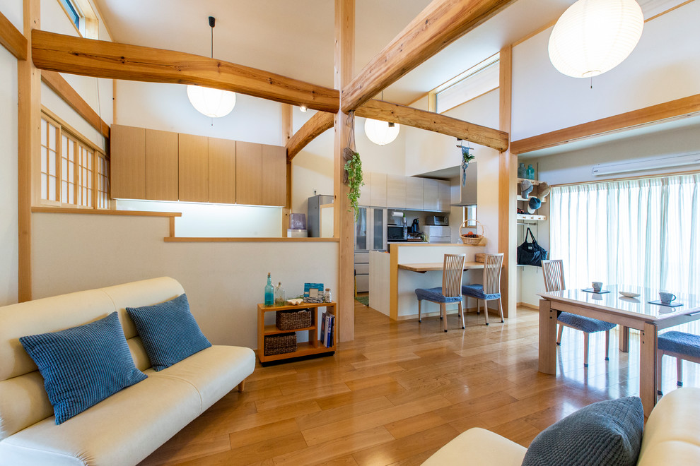 Imagen de salón abierto de estilo zen de tamaño medio con paredes blancas, suelo de madera en tonos medios y suelo marrón